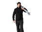 Homme en veste polaire noire et pantalon de ski, skis sur l'épaule.