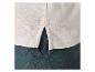 T-shirt beige et pantalon vert foncé en lin.