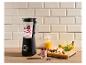 Mixeur noir avec baies et yaourt, fruits et granola sur un comptoir en bois.