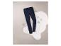 Un jean bleu foncé pour femme sur un fond de fourrure blanc.