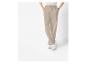 Pantalon beige avec des baskets blanches.