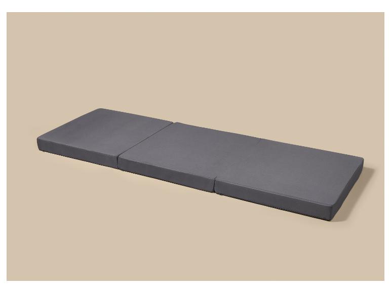 Matelas gris pliable à trois segments sur fond beige clair.