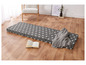 Trois matelas gris à étoiles blanches sur un sol en bois.