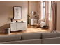 Salon confortable avec commode blanche, fauteuil et canapé dans des tons neutres.
