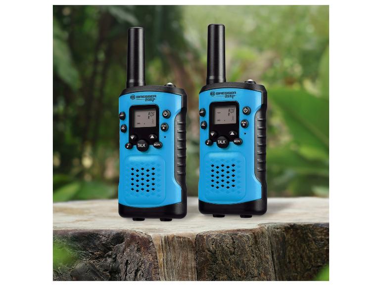 Deux talkie-walkies Bresser Junior bleus sur une souche d'arbre.