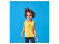 Petite fille en t-shirt jaune avec des citrons et un pantalon foncé, souriante.