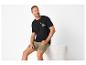 Homme assis, portant un t-shirt noir 'ROAD TRIPPIN' et un short kaki.