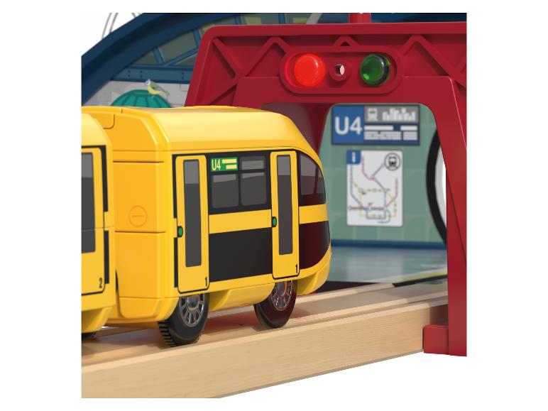Un train en bois jaune roulant sur une voie ferrée.