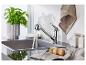 Robinet de cuisine chromé, évier en acier inoxydable et accessoires de cuisine.