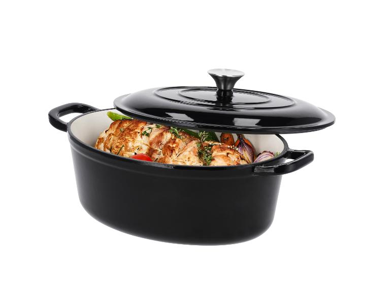 Cocotte ovale en fonte noire avec couvercle, remplie de poulet et légumes.