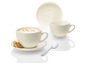 Une tasse de cappuccino avec un biscuit et une cuillère sur une soucoupe blanche.