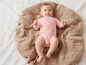 Un bébé allongé sur une couverture tricotée.