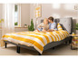 Un couple dans un lit avec des draps rayés.