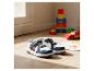Baskets pour enfants avec motifs de voitures, jouets et dessins sur un sol en bois.