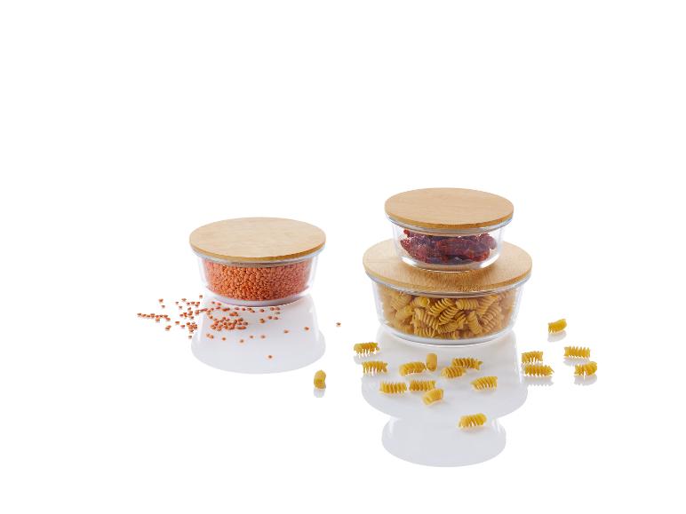 Bocaux en verre avec des couvercles en bambou remplis de pâtes, de tomates séchées et de lentilles.