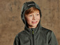 Un garçon porte une veste softshell verte à capuche.