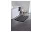 Un tapis de bain noir avec un motif de pierres dans une salle de bain