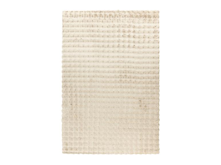 Un tapis beige en peluche avec un motif gaufré.