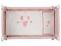 Un lit de poupée en bois rose avec des draps à cœurs.