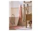 Serviettes roses et beiges dans une salle de bain avec baignoire et meuble.