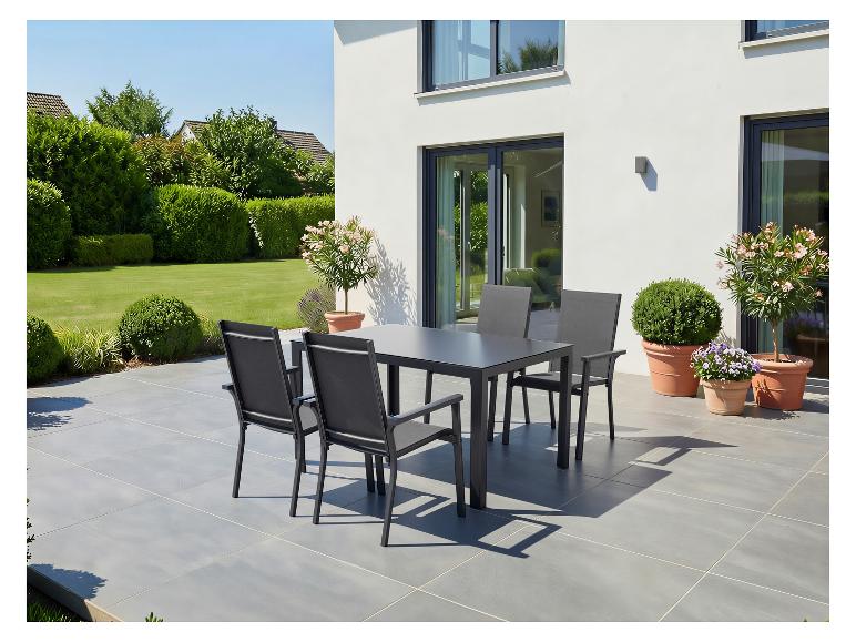 Ensemble de salle à manger d'extérieur avec une table gris foncé et quatre chaises sur une terrasse.
