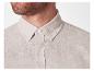 Chemise en lin beige boutonnée.