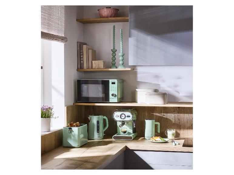 Appareils de cuisine vert menthe: micro-ondes, grille-pain, bouilloire et machine à expresso sur un comptoir en bois.