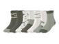 Lot de sept paires de chaussettes pour enfants avec imprimés dinosaures et inscriptions dans les tons verts et blancs.