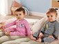 Deux bébés vêtus de pyjamas rayés et roses.