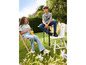 Deux enfants en jeans et t-shirts assis à une table en plein air.