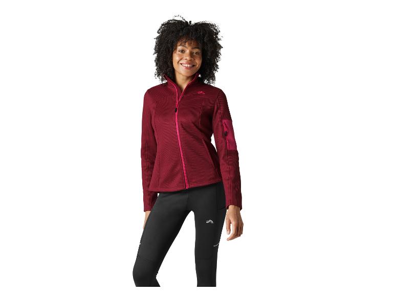 Femme souriante en veste polaire bordeaux et leggings noirs