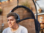 Un homme avec un casque audio se détend dans un fauteuil suspendu.