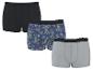 Trois boxers en coton pour hommes : un noir, un à motif ananas et palmiers, et un gris.