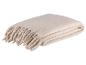 Douce couverture beige avec franges.