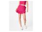 Femme en crop top et mini-jupe à volants fuchsia, baskets blanches