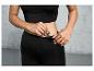 Une femme met une clé dans la poche de son legging noir.