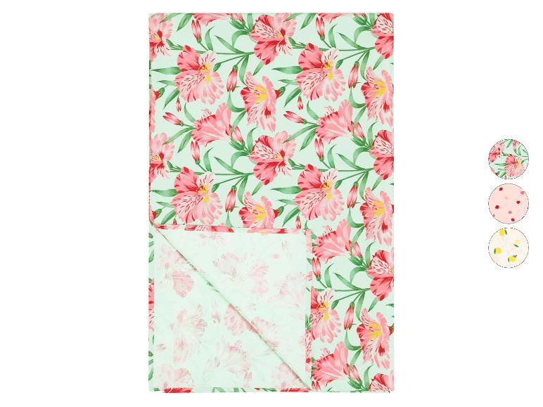 Nappe à motifs floraux avec des fleurs roses sur fond vert clair, avec d'autres motifs.
