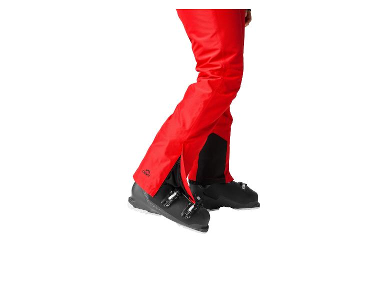 Pantalon de ski rouge avec chaussures de ski noires et fermetures éclair.