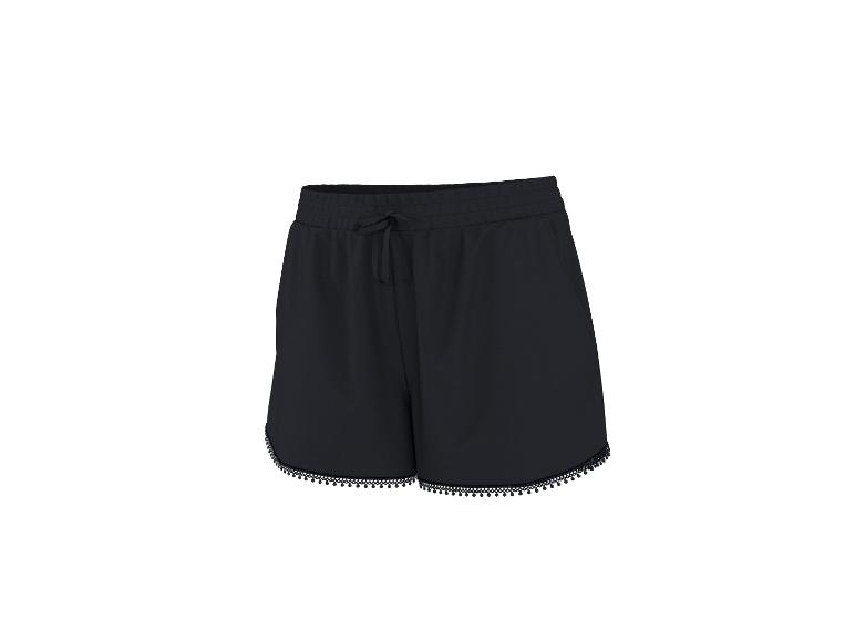 Shorts noirs avec cordon de serrage à la taille et détails de pompons sur l'ourlet.