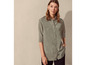 Une femme porte une chemise verte à manches longues.