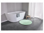 Une baignoire blanche avec un tapis de bain vert et un tabouret en bois.