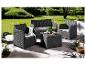 Un salon de jardin en osier noir avec deux fauteuils, un canapé deux places et une table basse