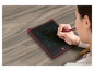 Une femme dessine avec un stylet sur une tablette graphique.