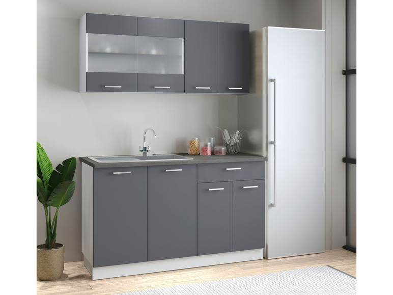 Une cuisine avec des armoires grises, un évier et un réfrigérateur.