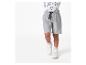 Un garçon portant un short de jogging gris et des baskets blanches.