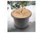 Une plante en pot avec un disque en fibre de coco sur le dessus, entourée de neige.