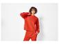 Une femme portant un sweat-shirt et un pantalon de jogging rouges.