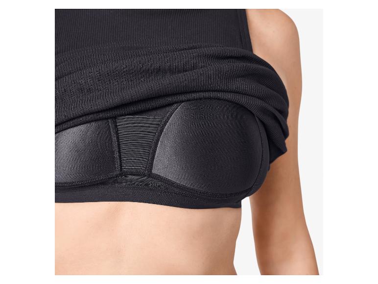 Haut côtelé noir sur une brassière de sport noire à bonnets rembourrés.