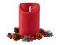 Une bougie LED rouge entourée de branches de sapin et de pommes de pin.