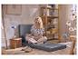 Femme assise sur le matelas pliant gris 2-en-1 de LIVARNO home.